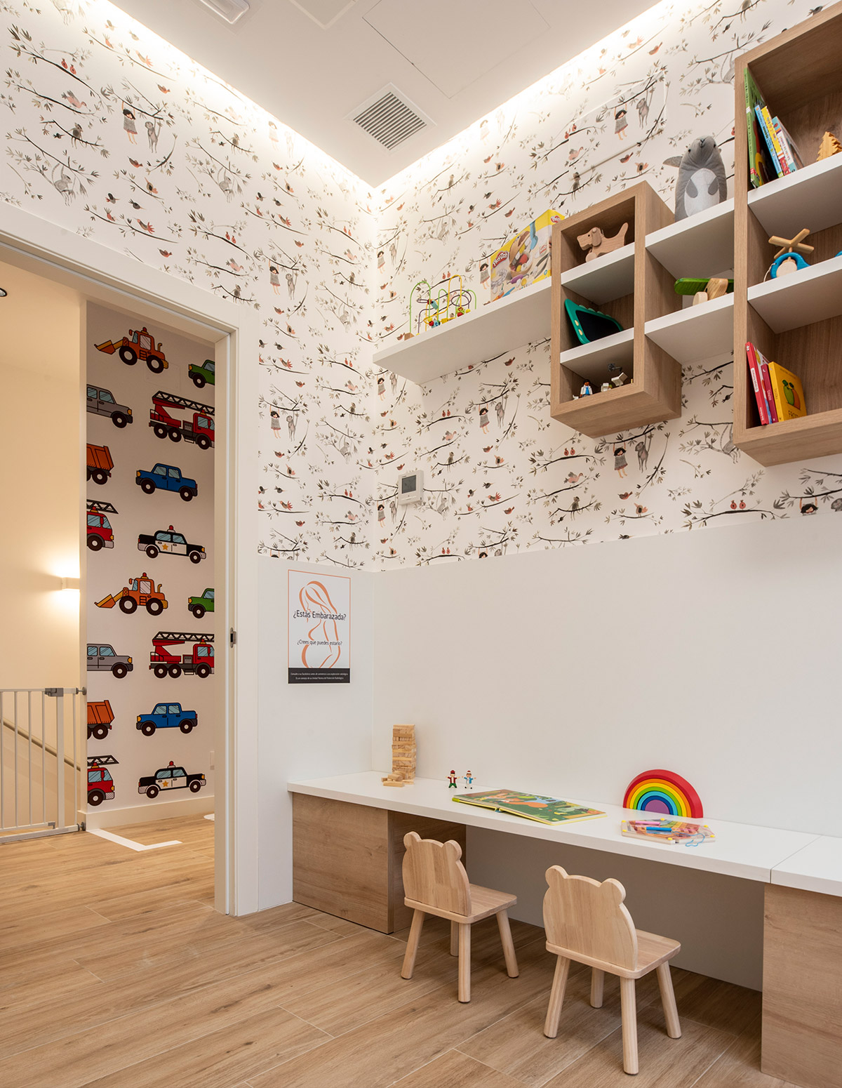Reforma de clínica dental en Santiago de Compostela. sala de espera infantil con mobiliario e decoración de paredes adaptado